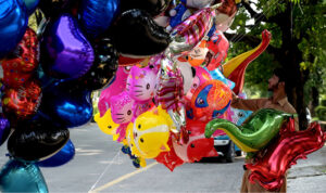 A vendor selling colorful balloons while shuttling on the road at Jinnah Super in the Federal Capital