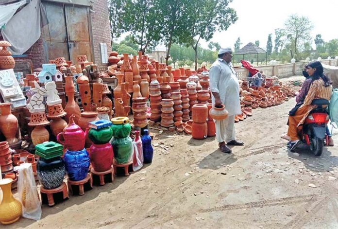 A vendor display and sells pottery at his roadside setup
