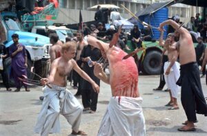 Mourners oozing themselves with knives and chains during the procession of Ashura on 10th Muharram-ul-Harram at Tibet Center. Muharram is the mourning month in remembrance of the martyrdom (Shahadat) of Hazrat Imam Hussain (RA), the grandson of the Holy Prophet Mohammad (PBUH).