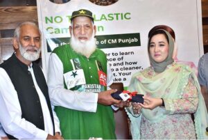 Chairperson of Women's Chamber of Commerce, Dr. Maryam Nauman, presenting a bag To Chacha Cricket (Haji Abdul Jalil) during a seminar ‘’No to Plastic campaign” on the initiative of Chief Minister Punjab organized by WCCIS