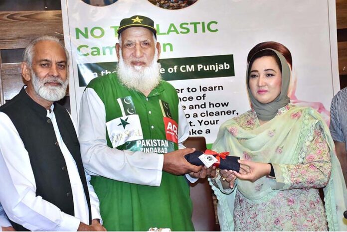 Chairperson of Women's Chamber of Commerce, Dr. Maryam Nauman, presenting a bag To Chacha Cricket (Haji Abdul Jalil) during a seminar ‘’No to Plastic campaign” on the initiative of Chief Minister Punjab organized by WCCIS