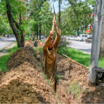 A laborer busy digging the ground to lay cable for a CCTV camera at Sector F-7/2