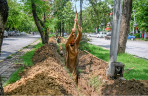 A laborer busy digging the ground to lay cable for a CCTV camera at Sector F-7/2