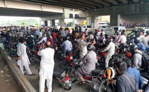 Motorcyclists taking shelter under the bridge of Faizabad Interchange during heavy rain in the Federal Capital.