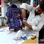 A vendor repairing school bags at Abpara Market in the Federal Capital