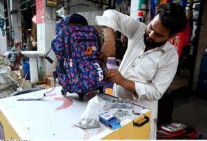 A vendor repairing school bags at Abpara Market in the Federal Capital