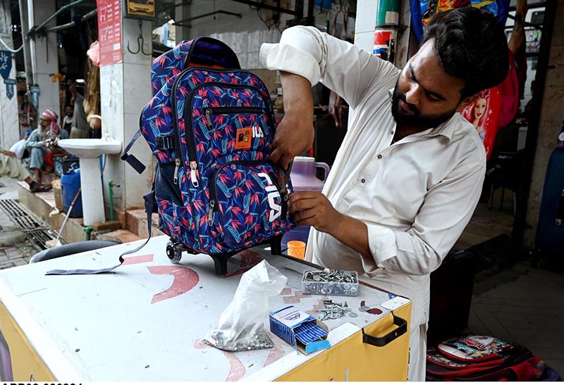 A vendor repairing school bags at Abpara Market in the Federal Capital