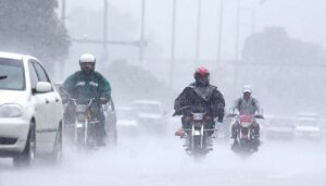 A motorcyclist rides through heavy rain on the Islamabad Expressway, facing reduced visibility and slippery road conditions due to torrential rain .