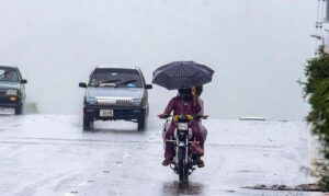 Motorcyclists taking shelter under the bridge of Faizabad Interchange during heavy rain in the Federal Capital.