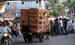 A labourer on the way pulling a heavily loaded handcart to deliver the stuff to shops at Liaquat Bagh