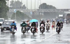 A motorcyclist rides through heavy rain on the Islamabad Expressway, facing reduced visibility and slippery road conditions due to torrential rain .