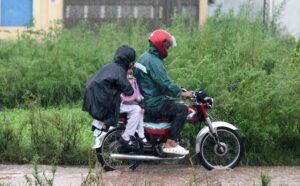 Motorcyclists taking shelter under the bridge of Faizabad Interchange during heavy rain in the Federal Capital.