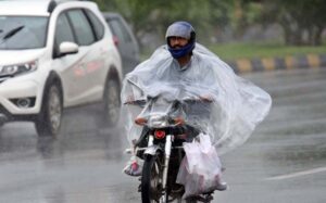 A motorcyclist rides through heavy rain on the Islamabad Expressway, facing reduced visibility and slippery road conditions due to torrential rain .