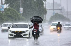 Vehicles passing through rainwater accumulated at IJP Road during heavy rain in Federal Capital.