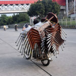 A vendor selling chairs while riding his motorbike at 9th avenue in the Federal Capital