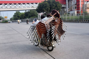 A vendor selling chairs while riding his motorbike at 9th avenue in the Federal Capital