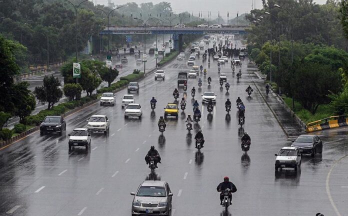Vehicles and bikers make their way through heavy rain at Zero Point in the Federal Capital