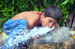 A youngster crunch his thirst while drinking water from tap.