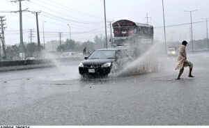 Vehicles passing through rainwater accumulated at IJP Road during heavy rain in Federal Capital.