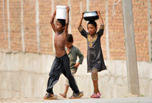 Children on their way back carrying pots after filling clean drinking water