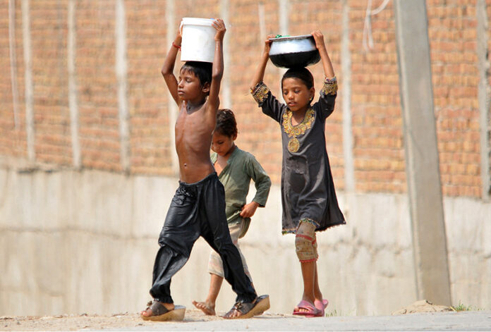 Children on their way back carrying pots after filling clean drinking water
