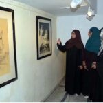 Women intently admire a painting of Ustad Nusrat Fateh Ali Khan at a special exhibition organized by the Arts Council on the occasion of his 27th birth anniversary