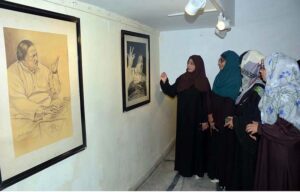 Women intently admire a painting of Ustad Nusrat Fateh Ali Khan at a special exhibition organized by the Arts Council on the occasion of his 27th birth anniversary