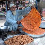An elderly vendor prepares traditional Katlamas, a famous local delicacy,enticing customers with the savory aroma and authentic taste at his roadside stall
