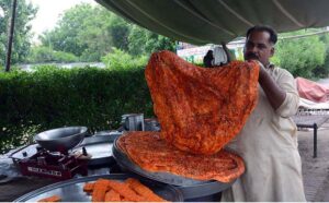 A vendor prepares traditional Katlamas, a famous local delicacy, enticing customers with the savory aroma and authentic taste at his roadside stall