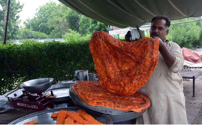 A vendor prepares traditional Katlamas, a famous local delicacy, enticing customers with the savory aroma and authentic taste at his roadside stall
