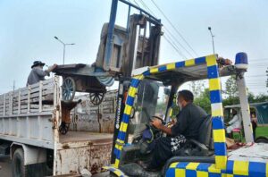 Traffic police officials loading hand carts on a delivery truck during operation against encroachment at Haji Camp GT Road.