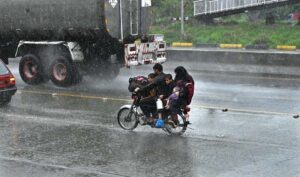 Vehicles passing through rainwater accumulated at IJP Road during heavy rain in Federal Capital.