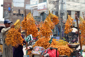 A vendor is busy displaying fresh dates to attract customers at his roadside setup
