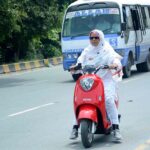 Woman on the way riding Scooty heading towards her destination