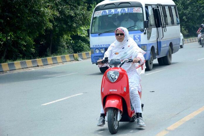Woman on the way riding Scooty heading towards her destination