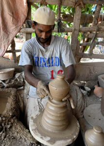 A worker arranging clay-made pitcher for drying purpose at his workplace at Kumharpara near Jamshoro road.