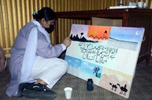 An art student participates in a painting competition that combines art and calligraphy, organized by the Punjab Arts Council Faisalabad for International Youth Day.