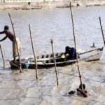 Fishermen engage in traditional technique of catching fish from their boats on the Rice Canal