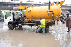 Workers of Municipal Corporation draining rain water in front of DHQ Hospital