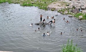 Youngsters swimming in a water pond near Rawal Dam to keep them cool during the hot and humid weather in the Federal Capital.