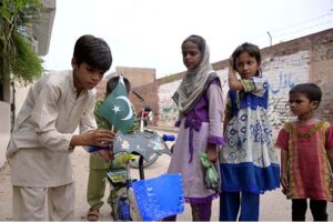A patriotic child decorates his bicycle with a Pakistan flag in preparation for the upcoming Independence Day celebrations in Hyderabad
