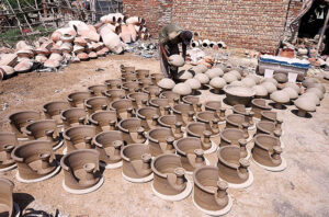 A worker arranging clay-made pitcher for drying purpose at his workplace at Kumharpara near Jamshoro road.