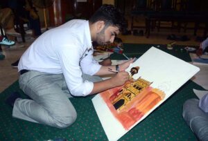 An art student participates in a painting competition that combines art and calligraphy, organized by the Punjab Arts Council Faisalabad for International Youth Day.