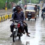 A motorcyclist on the way during heavy rain in the city