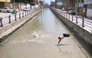 Youngsters jumping and bathing in a Canal at Gulbahar area to get some relief from scorching hot and humid weather in Provincial Capital.
