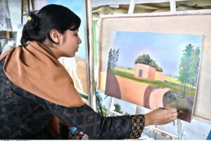 A young girl student busy in making painting at Peshawar Mor Sunday Bazaar.