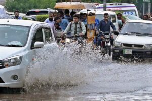 Vehicles passing through rainwater accumulated on road at College Road after heavy rain in the city.