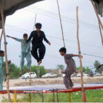 Youngsters enjoy jumping on a trampoline at the roadside