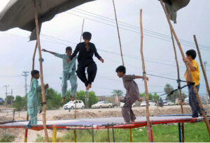 Youngsters enjoy jumping on a trampoline at the roadside