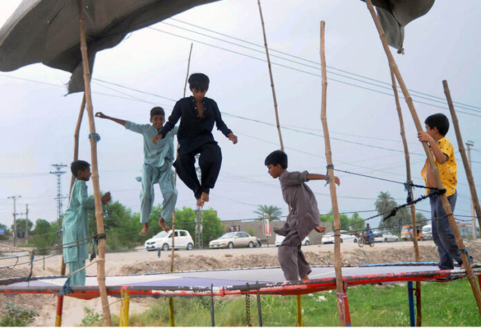 Youngsters enjoy jumping on a trampoline at the roadside